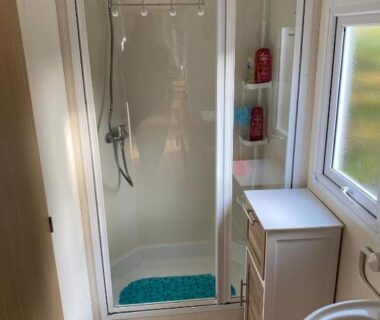 Salle de douche avec cabine et lavabo du Mobil Home