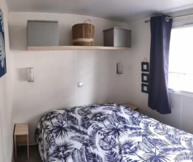 Chambre avec lit double étagères et fenêtre dans le Mobil Home 2 chambres avec terrasse
