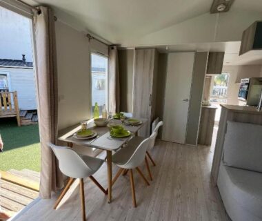 Séjour avec table à manger et baie vitrée donnant sur terrasse du Mobil Home 2CH Bien Equipé Valras-Plage