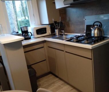 Cuisine équipée avec table et baie vitrée dans le Mobil Home