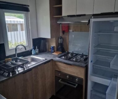 Cuisine équipée avec plan de travail et réfrigérateur dans le Mobil Home