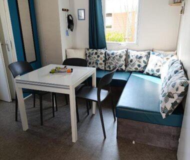 Coin repas avec banquette table et chaises dans le Mobil Home 3 chambres