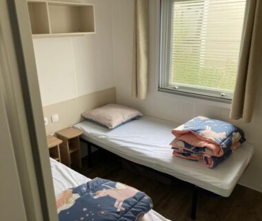 Chambre avec deux lits simples et table de chevet dans le Mobil Home 4-6 personnes