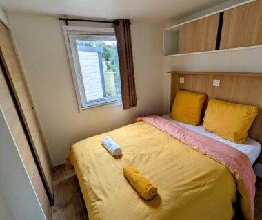 Chambre intérieure avec lit double et fenêtre dans le Mobil-Home 4-6 personnes camping 4 étoiles