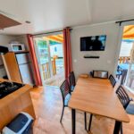 Intérieur avec coin repas et terrasse du mobil-home 4-6 personnes camping 4 étoiles