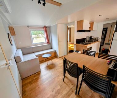 Séjour avec canapé table et kitchenette dans le Mobil-Home 4-6 personnes camping 4 étoiles