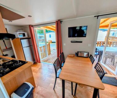 Intérieur avec coin repas et terrasse du mobil-home 4-6 personnes camping 4 étoiles