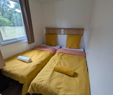 Chambre avec deux lits simples et fenêtre dans le Mobil-Home 4-6 personnes camping 4 étoiles