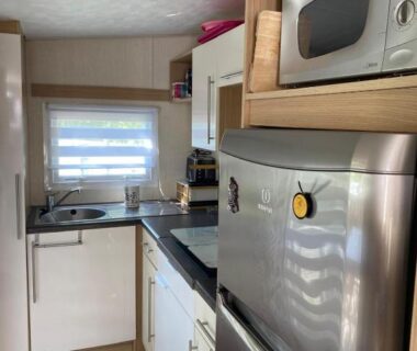 Cuisine équipée avec réfrigérateur micro-ondes et évier dans le Mobil Home