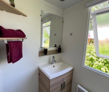 Salle de bain avec lavabo et miroir dans le Mobil-Home 4 étoiles avec piscine proche de Blois