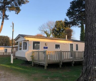 Terrasse en bois devant le mobil home entouré d'arbres au camping en Bretagne du Mobil Home 4 places 2 chambres