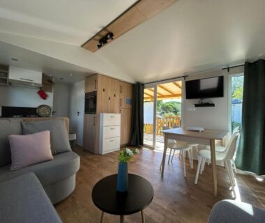 Intérieur avec salon canapé et coin repas du Mobil-Home 419 Camping Lac des rêves Siblu 3ch 40m2 MER