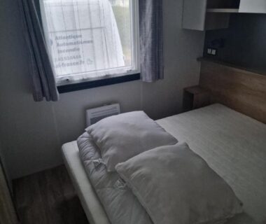 Chambre avec lit double et oreillers dans le Mobil Home