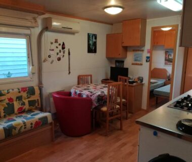 Intérieur avec coin repas canapé et kitchenette du Mobil Home 54 au Parc Résidentiel de la Plage