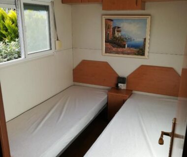 Chambre avec deux lits et fenêtre dans le Mobil-Home 54 au Parc Résidentiel de la Plage