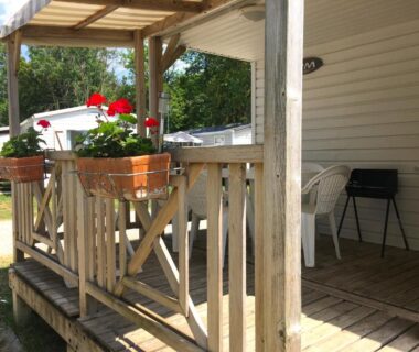 Terrasse en bois avec pots de géraniums et chaises du Mobil Home 5pers proche EUROPA PARK dans Camping 3étoiles