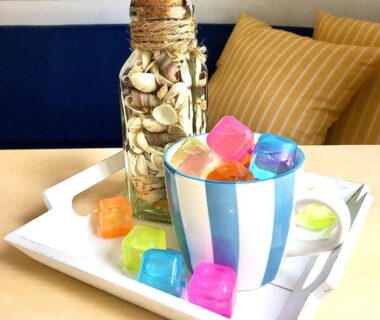 Table intérieure avec tasse rayée glaçons colorés et bocal coquillages dans le Mobil Home 5pers proche EUROPA PARK