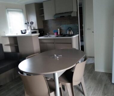 Coin repas avec table et kitchenette dans le Mobil Home