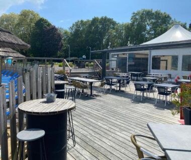 Terrasse en bois avec tables près de la piscine du Mobil Home