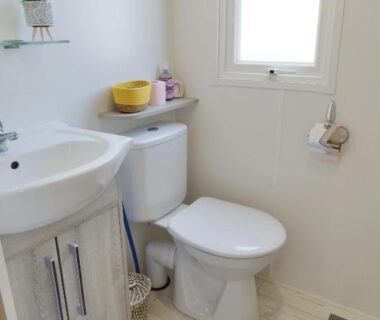 Salle de bain avec lavabo WC et fenêtre dans le Mobil Home 6-8p 3ch 2sb Clim