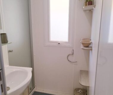 Salle de bain avec lavabo cabine de douche et fenêtre dans le Mobil Home 6-8p 3ch 2sb Clim