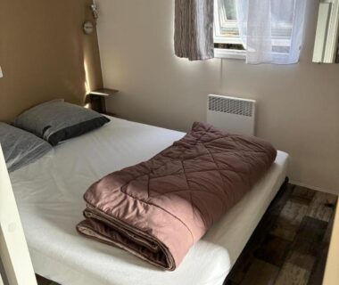 Intérieur chambre avec lit double et fenêtre du Mobil Home 6 à 8 personnes avec jardin
