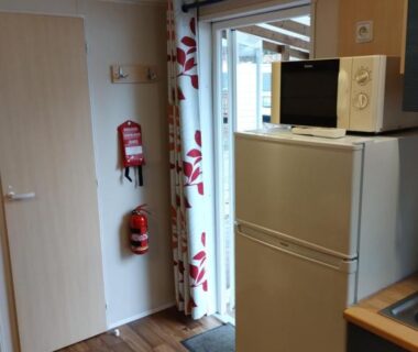 Intérieur avec réfrigérateur micro-ondes et porte-fenêtre du Mobil Home 6 pers 3 chambres piscine proche Europa Park