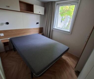 Chambre avec lit, rangements et fenêtre dans le Mobil Home 6 pers à Vias Plage