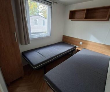 Dans la chambre deux lits simples et fenêtre du Mobil Home 6 pers à Vias Plage