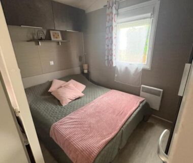 Chambre avec lit double et couverture rose dans le Mobil-Home 6 personnes