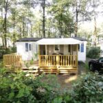 Terrasse bois entourée d'arbres dans le camping du Mobil Home 6 personnes 3 chambres à 25 MIN Puy duFou