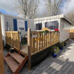 Terrasse en bois avec pots de fleurs et accès au Mobil-Home 6 personnes