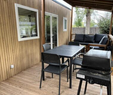 Terrasse couverte avec table, canapé et barbecue du Mobil Home 6 personnes La Marina