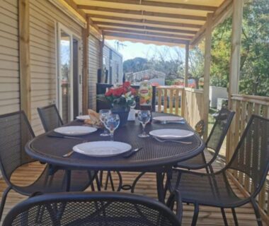 Terrasse couverte avec table dressée et chaises du Mobil-Home 6 places climatisé avec WIFI