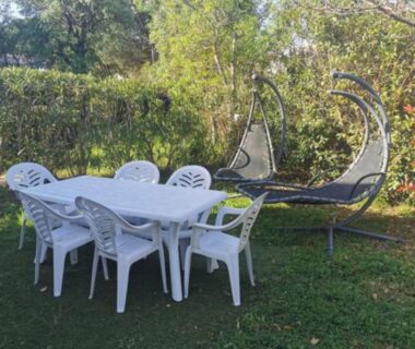 Jardin avec table et chaises blanches et fauteuils suspendus du Mobil-Home 6 places climatisé avec WIFI
