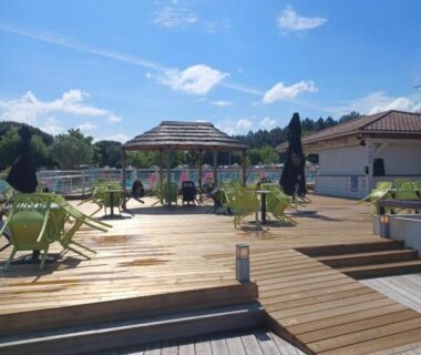 Terrasse en bois avec chaises longues et parasols au Mobil Home 710 Bora Bora 3 chambres