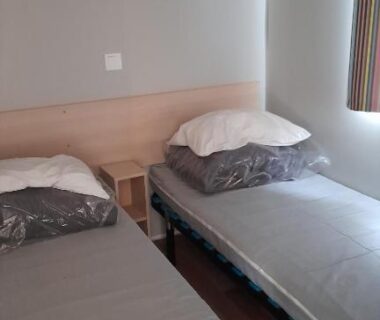 Chambre avec deux lits simples et fenêtre dans le Mobil Home AGDE