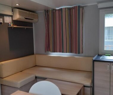Coin salon avec kitchenette et banquette dans le Mobil Home AGDE