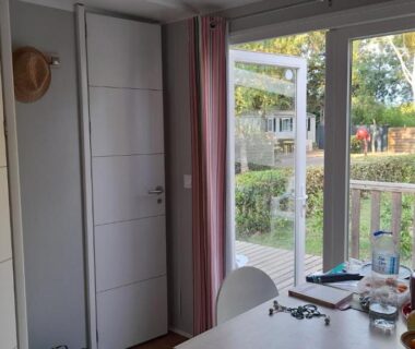 Intérieur avec table et baie vitrée donnant sur terrasse du Mobil Home AGDE
