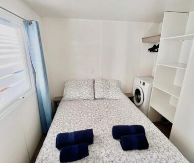 Chambre intérieure avec lit double serviettes et machine à laver dans le Mobil Home Abricotiers 1