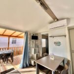Séjour avec terrasse couverte et table dans le Mobil Home Abricotiers 1