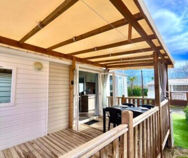 Terrasse en bois couverte avec salon extérieur dans le Mobil Home Abricotiers 1