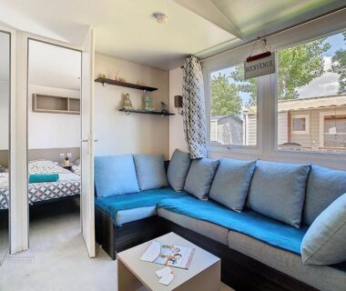Intérieur salon avec banquette et fenêtres dans le Mobil-Home CL 14 à Vias La Carabasse Camping Siblu avec piscine payante