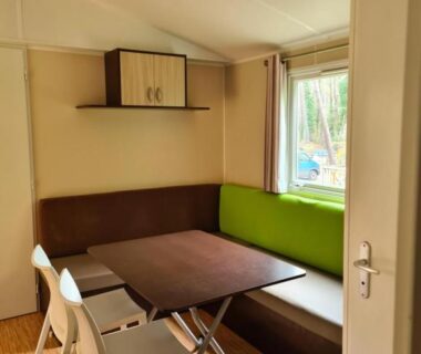 Coin repas avec banquette et table dans le Mobil Home Camiers