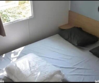 Intérieur chambre avec lit double et fenêtre dans le mobil-home Le Domaine de Chaussy