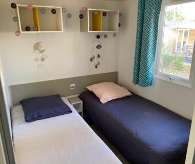 Intérieur chambre avec deux lits et étagères du Mobil-Home Camping Club 5* Montalivet