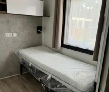Intérieur chambre avec lit simple et fenêtre dans le Mobil Home Cap Ferret