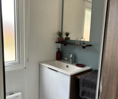 Salle de bain avec lavabo et miroir dans le Mobil Home Cap Ferret