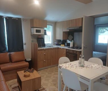 Salon avec kitchenette et table à manger dans le Mobil-Home Cosy 4-6p
