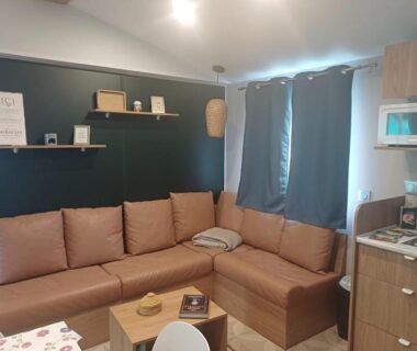 Intérieur salon avec banquette d'angle et kitchenette du Mobil-Home Cosy 4-6p Calme et Detente Terrasse couverte 4 etoiles